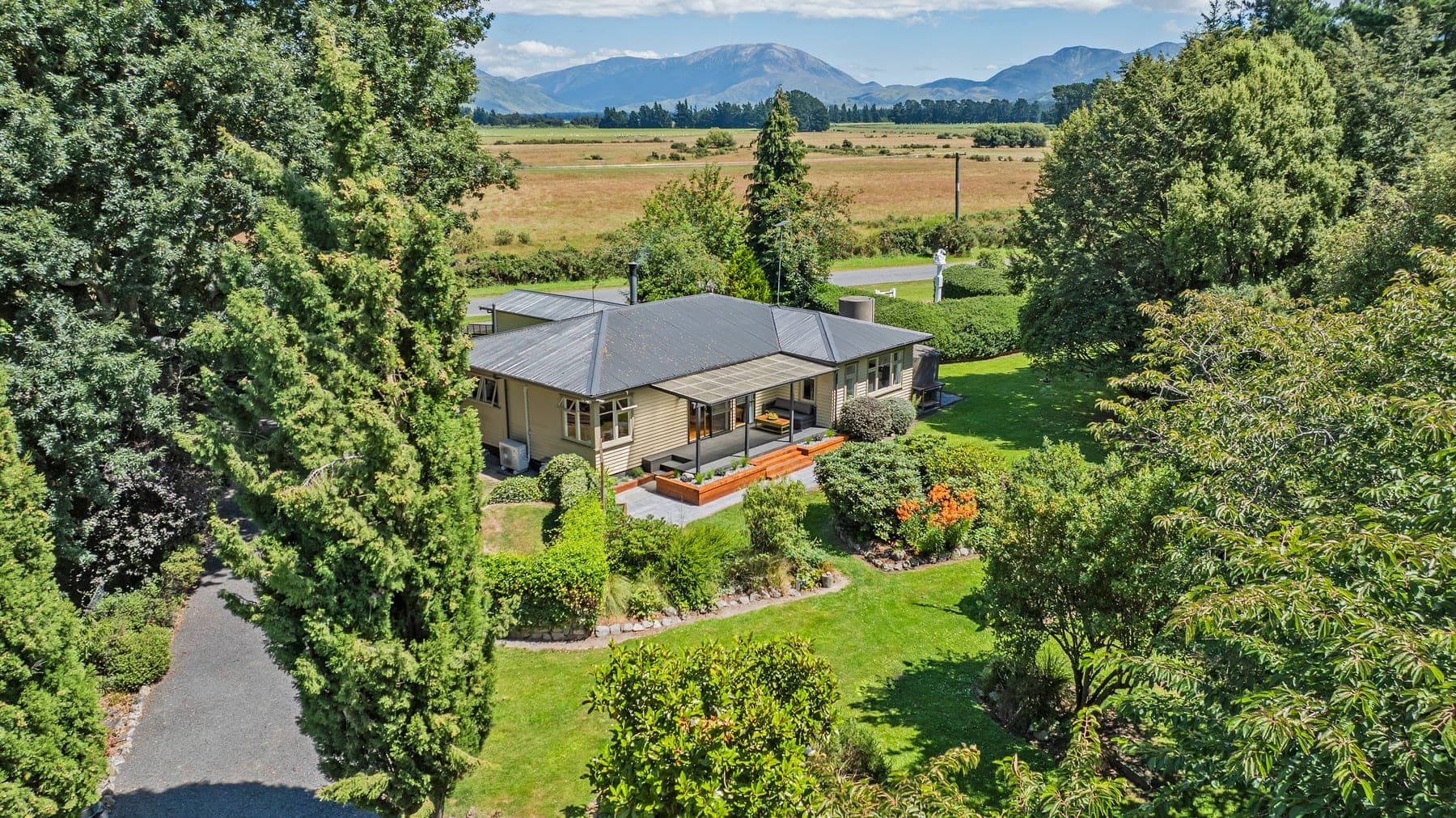 Aerial view of Kowai Farmstay surrounded by gardens and Canterbury mountain ranges